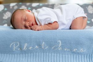 Baby on blue baby blanket with name