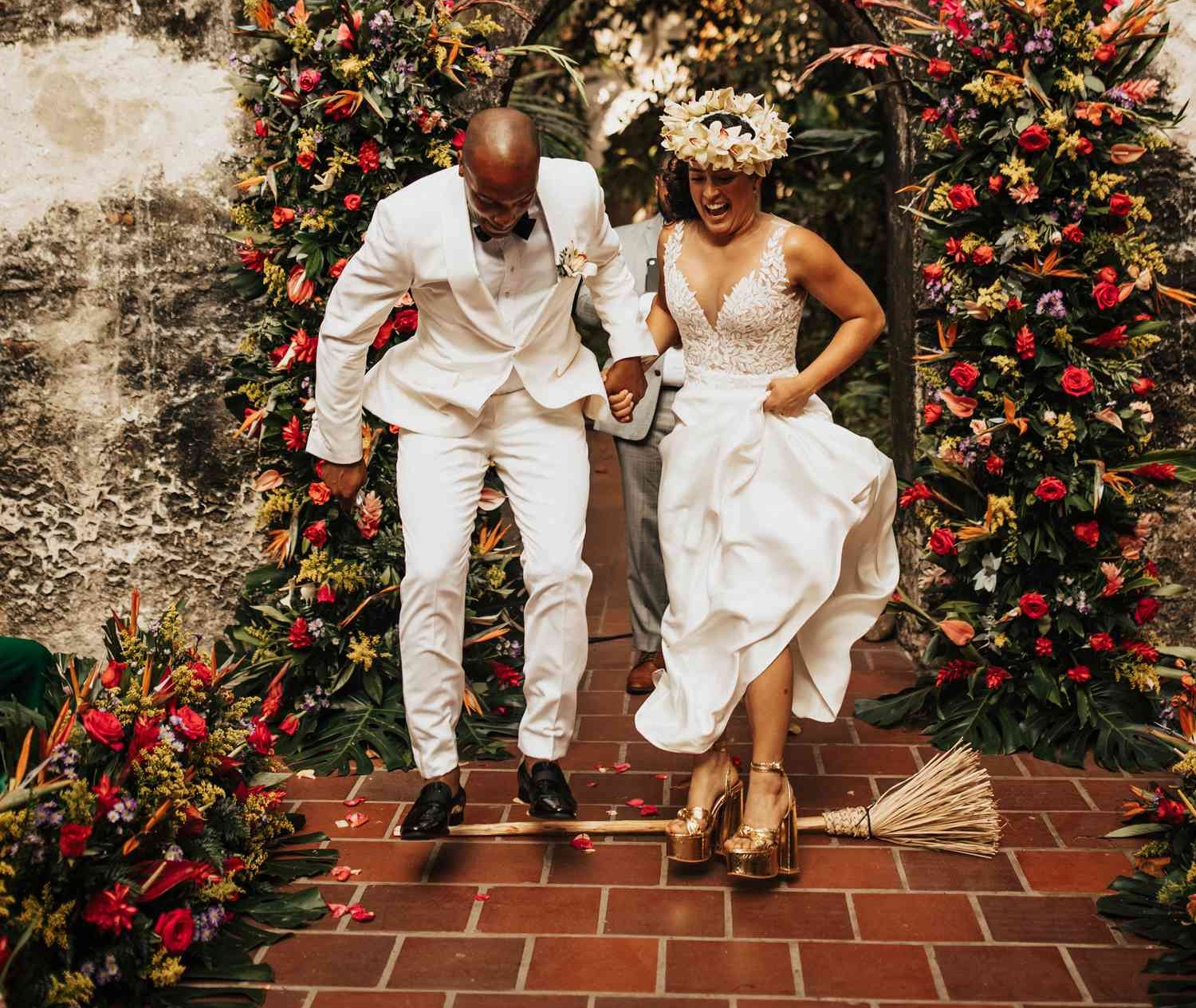 wedding couple jumping over a broom